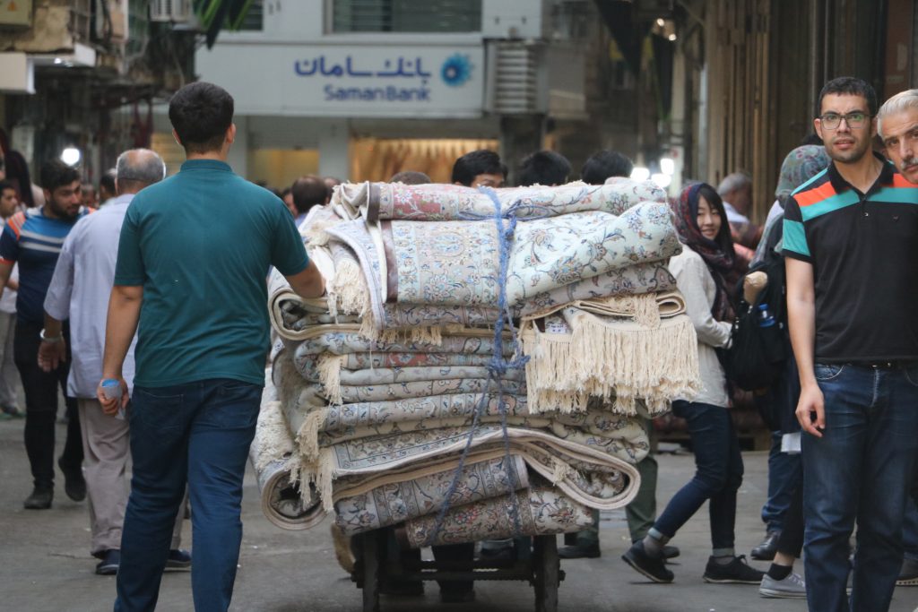 イランの首都テヘランのバザール内にて台車でペルシャ絨毯を運んでいる写真
